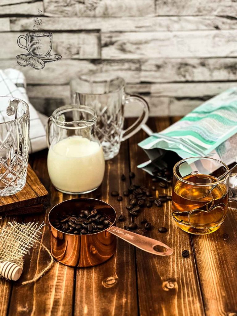 coffee beans in cup next to honey, milk and coffee glasses.