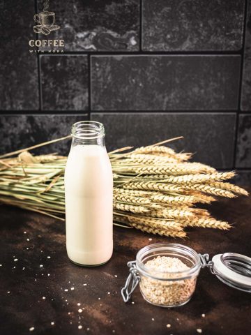 Milk bottle with oat milk on dark background.