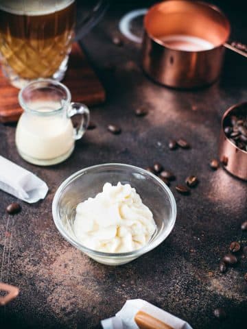 Whipped coffee creamer in small glass bowl.