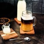 Coffee with coffee creamer in mason glass. Surrounded by containers filled with coffee creamer.