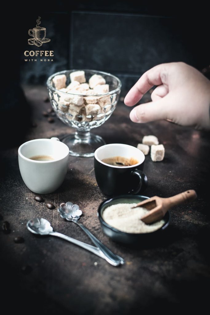 Dropping a brown sugar cube into a cup of coffee.