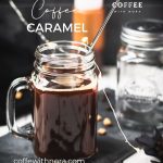 Mason jar filled with delicious coffee caramel. Placed on black slate, surrounded by coffee beans and caramel pieces.