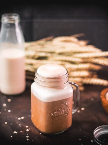 Mason jar filled with comforting oat milk coffee. So good!