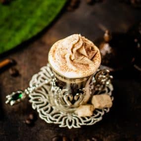 Beautiful pumpkin flavored whipped cream piped on black coffee.