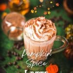 Coffee glass filled with delicious pumpkin spiced latte, garnished with whipped cream and dusted with a cocoa cinnamon mix. Placed on green felt.