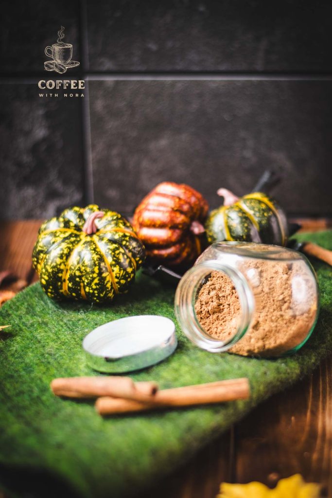 Cute jar, filled with homemade pumpkin spice mix, placed on green felt.