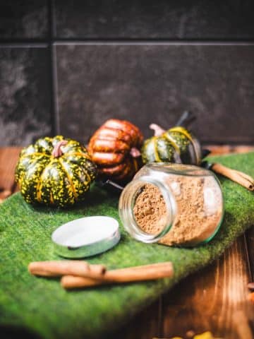 Cute jar, filled with homemade pumpkin spice mix, placed on green felt.