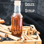 Preserving bottle filled with delectable brown sugar cinnamon syrup placed in wooden basket filled with cinnamon sticks.