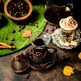 Delicious pumpkin spiced coffee with and without dairy topping filled in medieval serving glass.