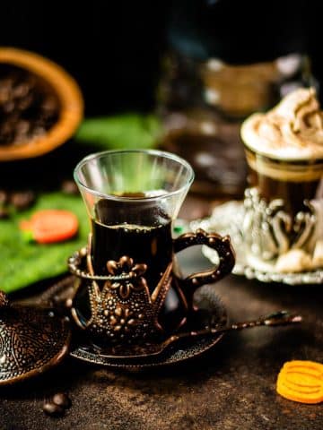 Delicious pumpkin spiced coffee with and without dairy topping filled in medieval serving glass.