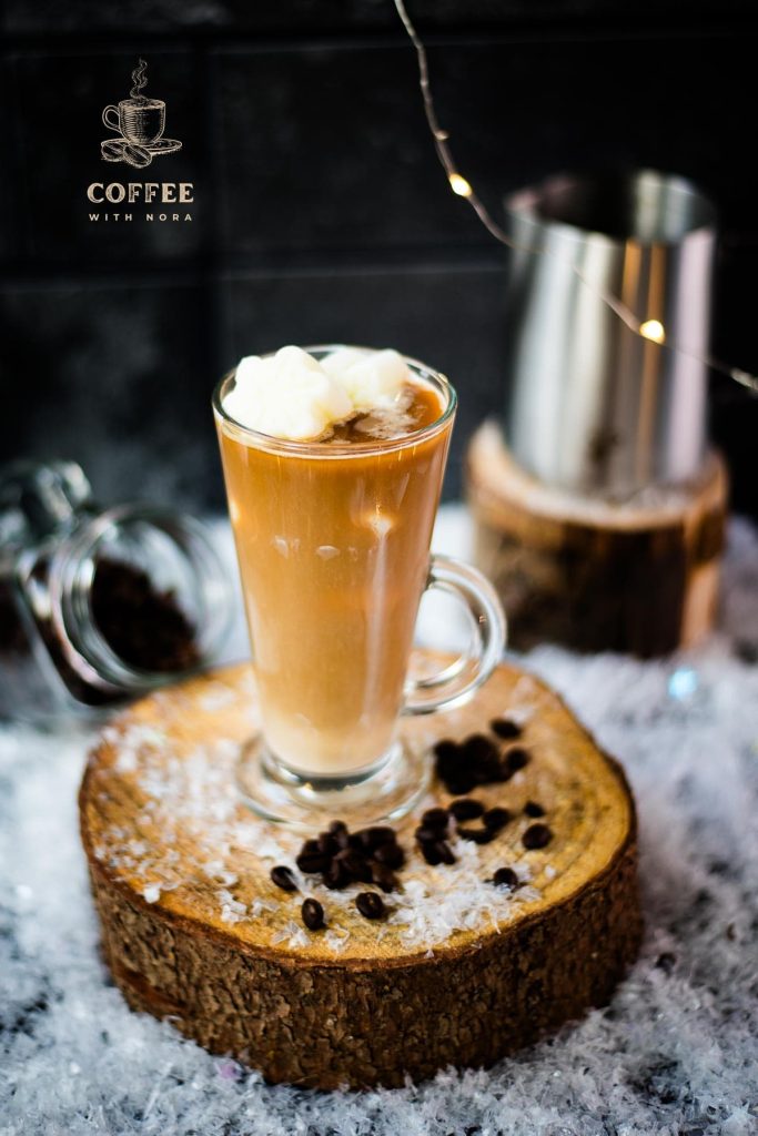 Gorgeous image of a high coffee glass, filled with iced coffee. The beautiful snowflake shaped milk ice cubes make this treat even more appealing.