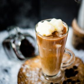 Gorgeous image of a high coffee glass, filled with iced coffee. The beautiful snowflake shaped milk ice cubes make this treat even more appealing.