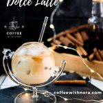 Gorgeous glass filled with iced cinnamon dolce latte. Placed on black slate plate.