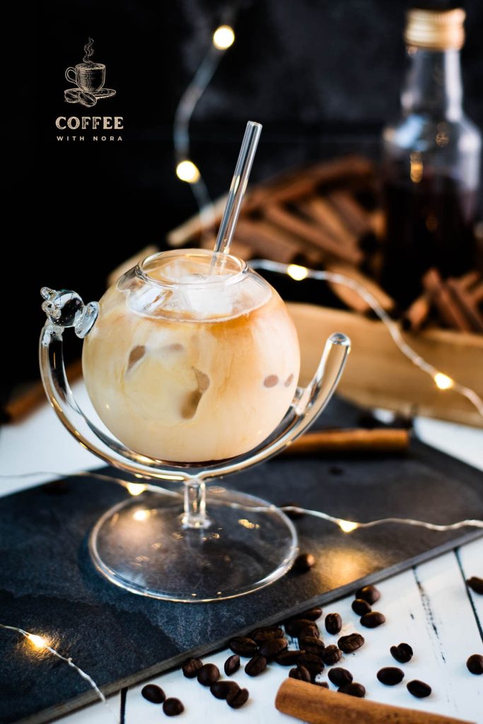 Gorgeous glass filled with iced cinnamon dolce latte. Placed on black slate plate.