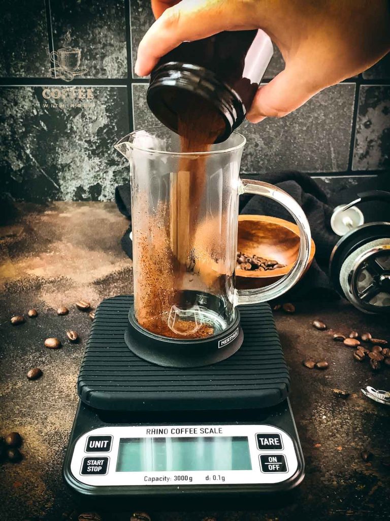 Pour the ground coffee into the preheated French press.