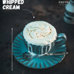 Blue coffee mug with coffee and maple syrup whipped cream topping. A little overflowing.