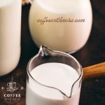 A bottle, a jug and a small container filled with different types of milk. Placed on a dark ground.