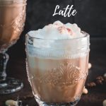 Gorgeous almond milk lattes, in gorgeous glasses, placed on dark floor.