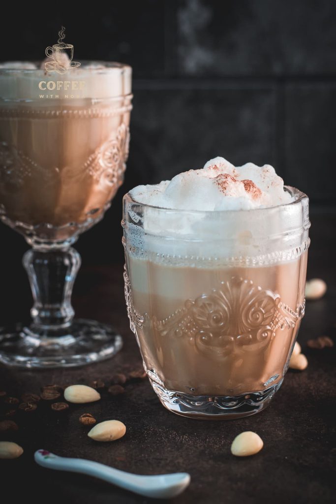 Gorgeous almond milk lattes, in gorgeous glasses, placed on dark floor.