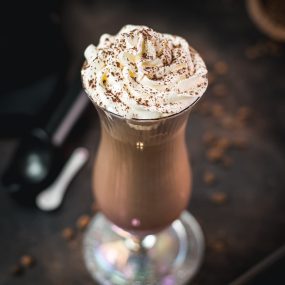 Delicious iced chocolate coffee with sweet whipping cream on top. Dusted with cocoa powder and served in a hurricane glass.