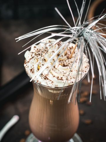 Delicious iced chocolate coffee with sweet whipping cream on top. Dusted with cocoa powder and served in a hurricane glass.