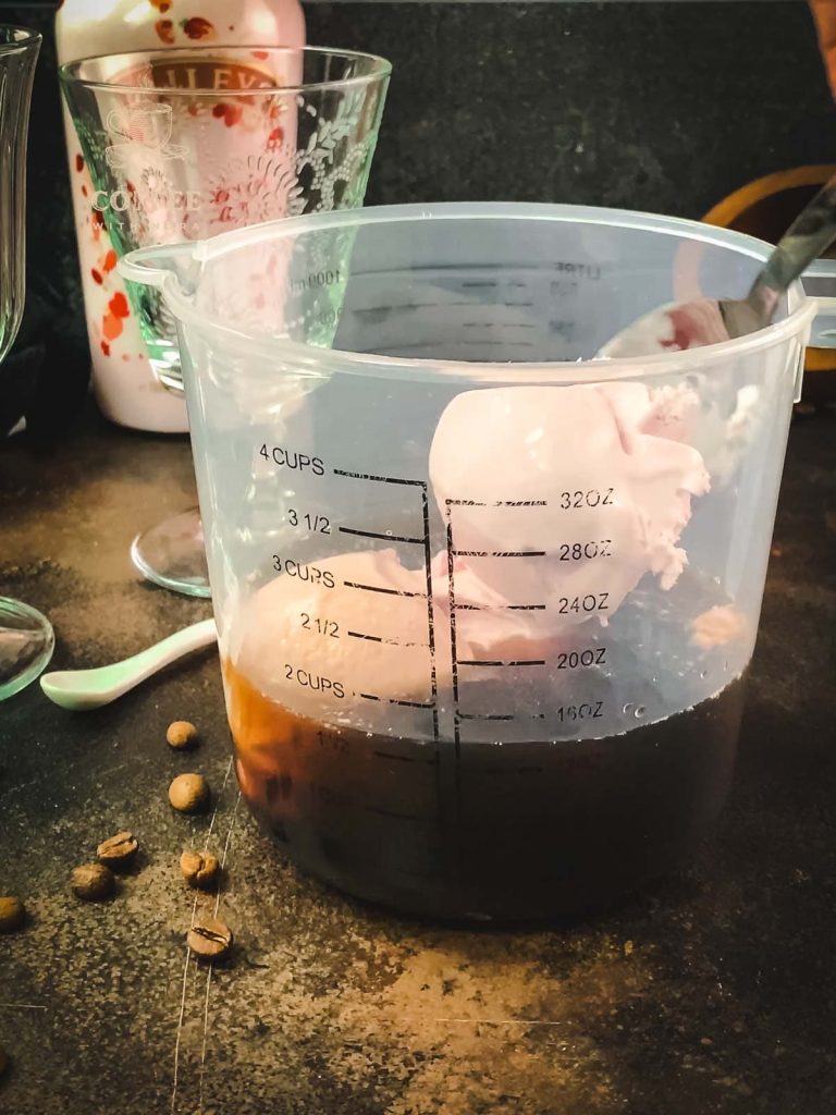 Tall mixing bowl filled with cold brew coffee and strawberry ice cream.