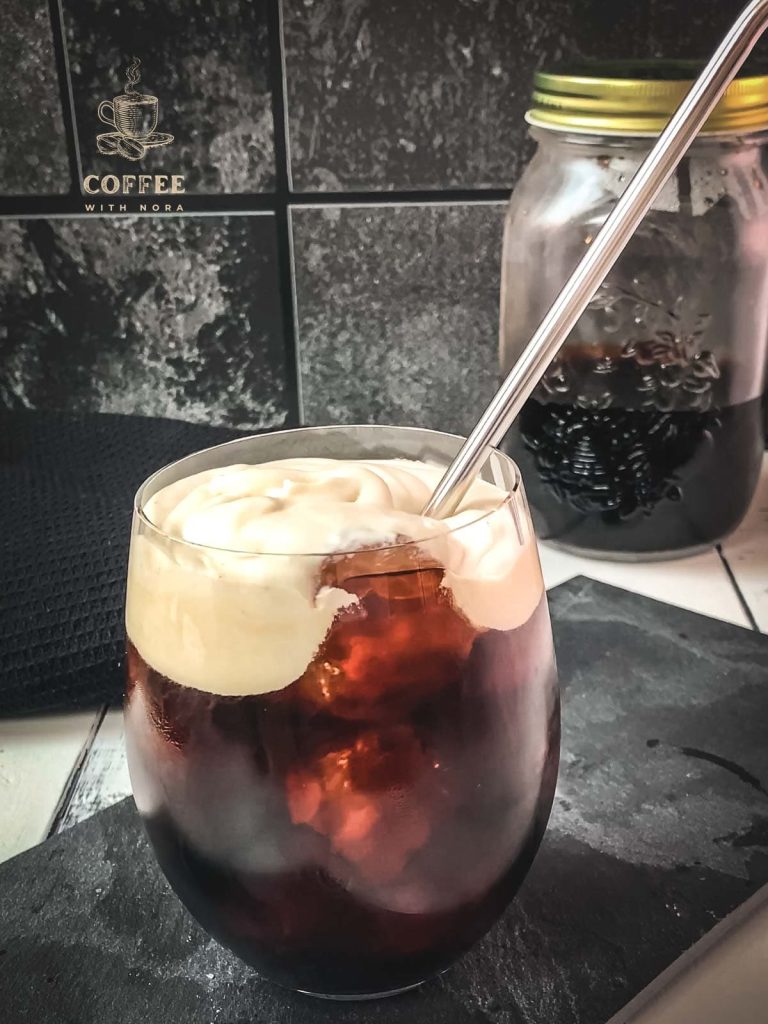 Placing a metal straw into the vanilla sweet cream cold brew.