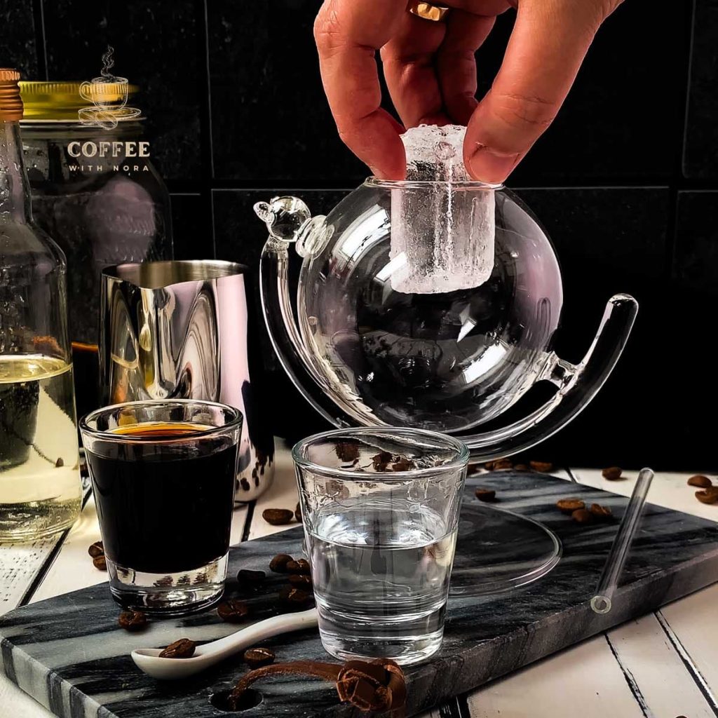 Placing an ice cube to the drinking glass.