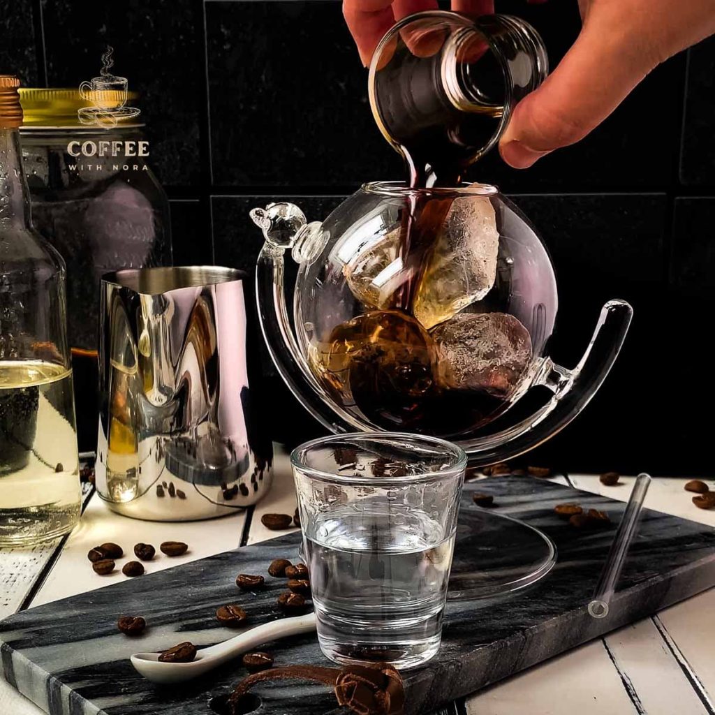 Pouring the cold brew into the cubed ice filled glass.