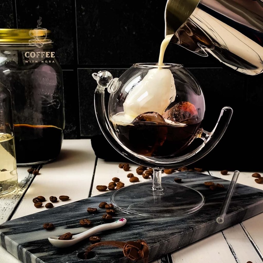 Pouring half-and-half into the serving glass filled with cold brew black Russian.