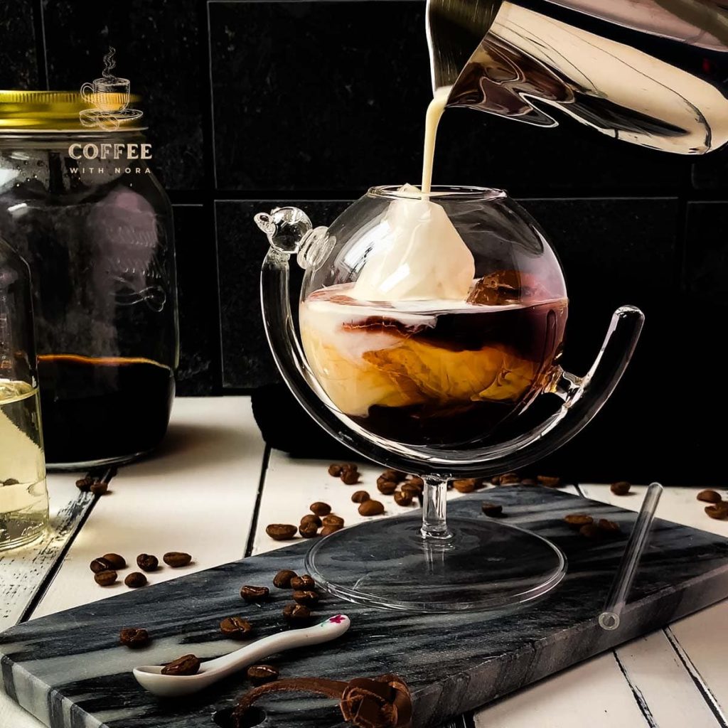 Pouring half-and-half into the serving glass filled with cold brew black Russian.