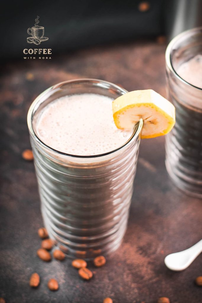 Two glasses filled with delicious, nutritious banana milk coffee. Garnished with a slice of banana. Perfect to start the day or as a pre-workout snack!