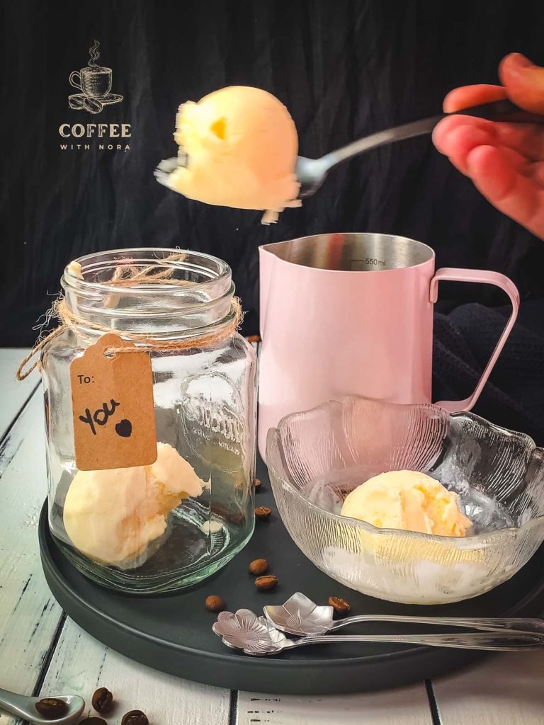 Placing 2-3 scoops of vanilla ice cream into a mason jar.