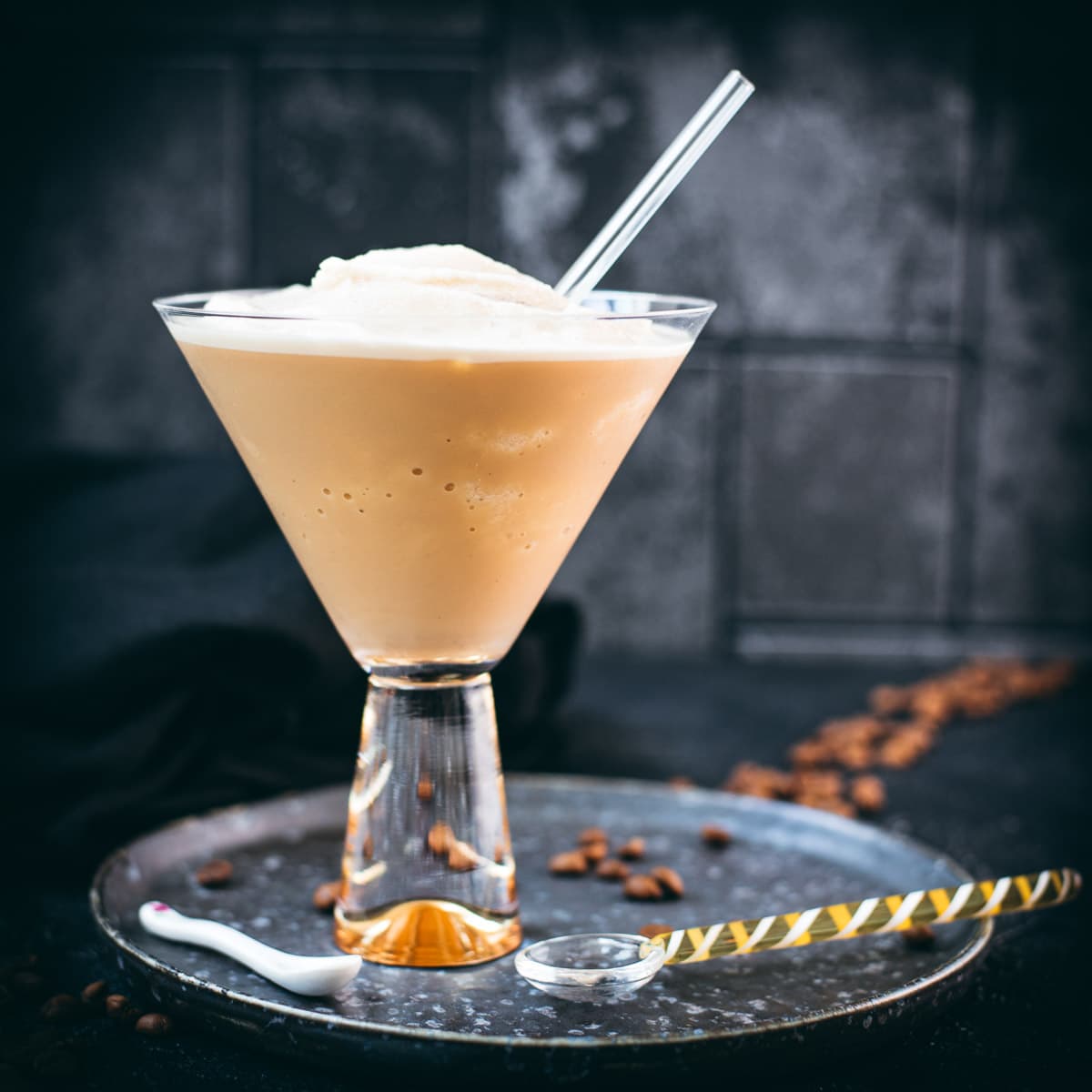 Gorgeous cocktail glass filled with a delicious homemade coffee slushy placed on a metal tray.