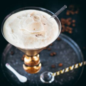 Gorgeous cocktail glass filled with a delicious homemade coffee slushy placed on a metal tray.