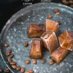 Frozen coffee cubes placed on metal plate next to coffee beans.