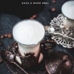 Gorgeous medieval glasses filled with delicious Breve coffee, placed on dark ground next to coffee beans.