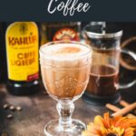 Rich French press Mexican coffee in gorgeous serving glass, placed on brown colored ground, next to orange-colored flower.