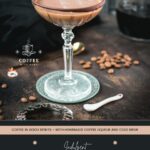 Creamy mocha martini in gorgeous glass, placed on glass coaster on dark ground.