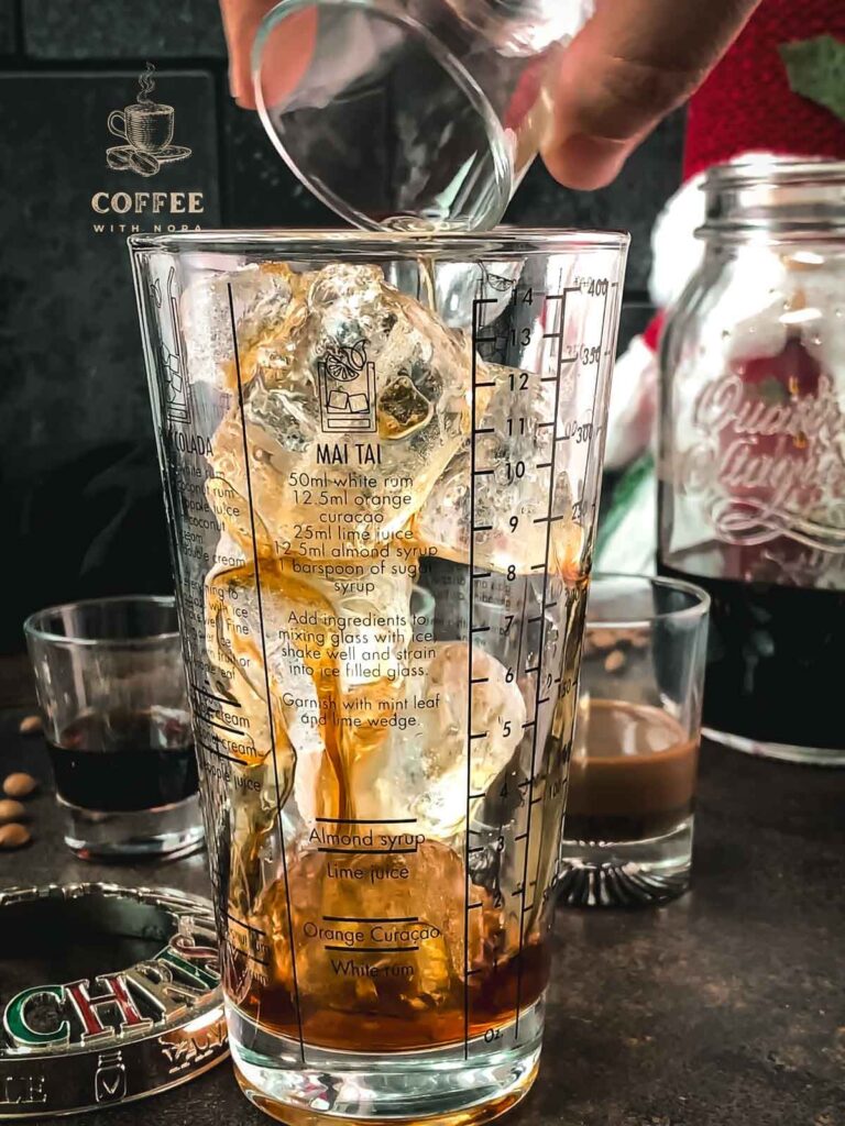 Pouring the cold brew into the cocktail shaker.