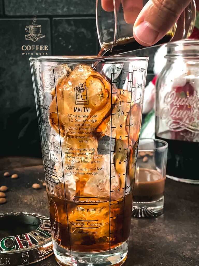 Pouring the coffee liqueur into the cocktail shaker.