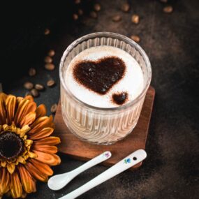 Gorgeous Cortado coffee, served in glass mug and dusted with cocoa powder.