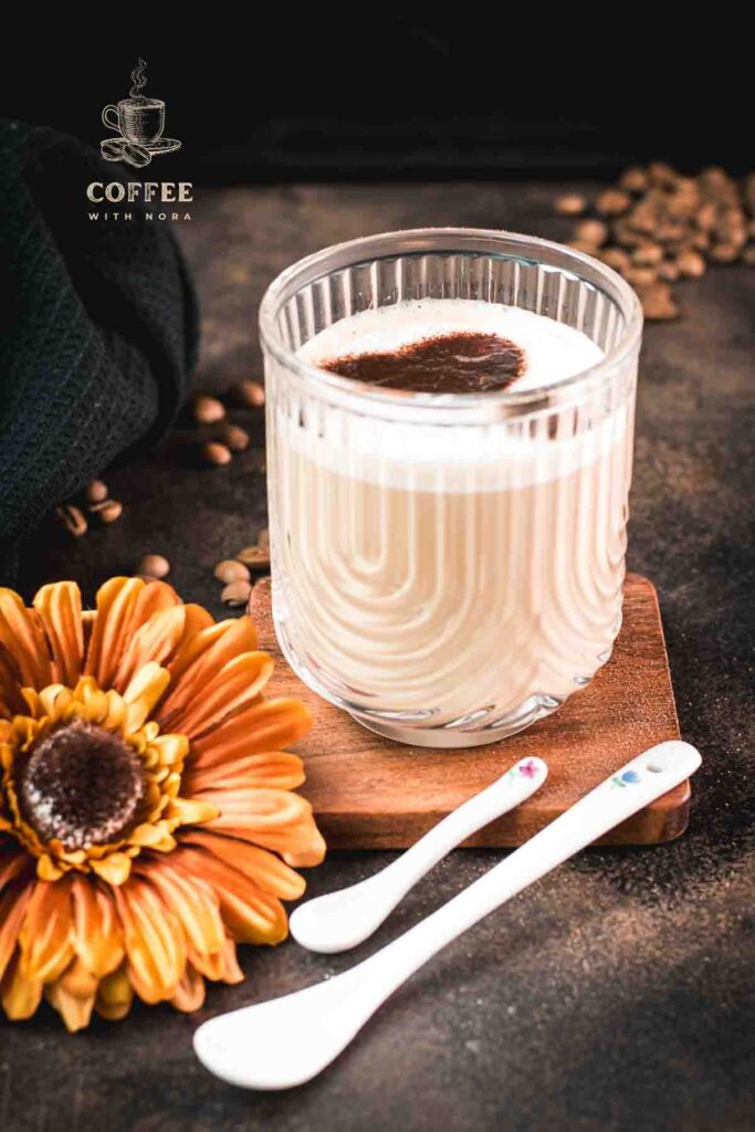 Gorgeous Cortado coffee, served in glass mug and dusted with cocoa powder.