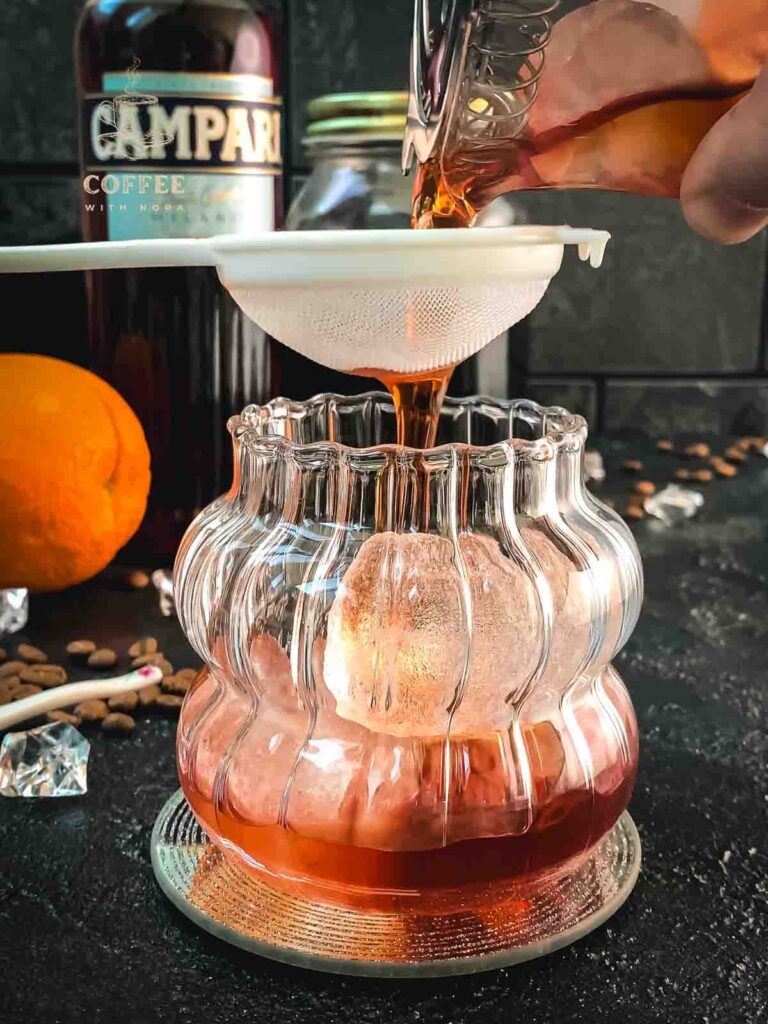 Fine strain the cold brew negroni into the rocks glass.