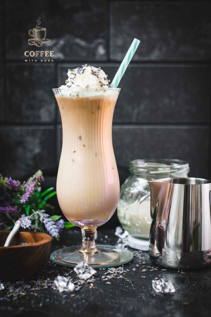Gorgeous Hurricane glass, filled with crushed lavender iced latte, topped with whipped cream and sprinkled with lavender buds. Served with a turquoise white striped drinking straw.