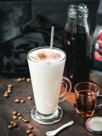 Beautiful glass filled with hot milk and homemade coffee syrup. Topped with frothed milk and dusted with cinnamon.