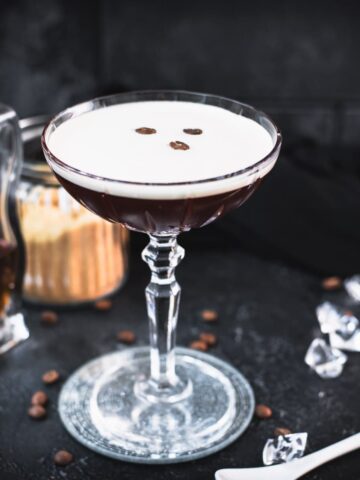 Brown sugar espresso martini placed on mirrored coaster, garnished with three coffee beans.