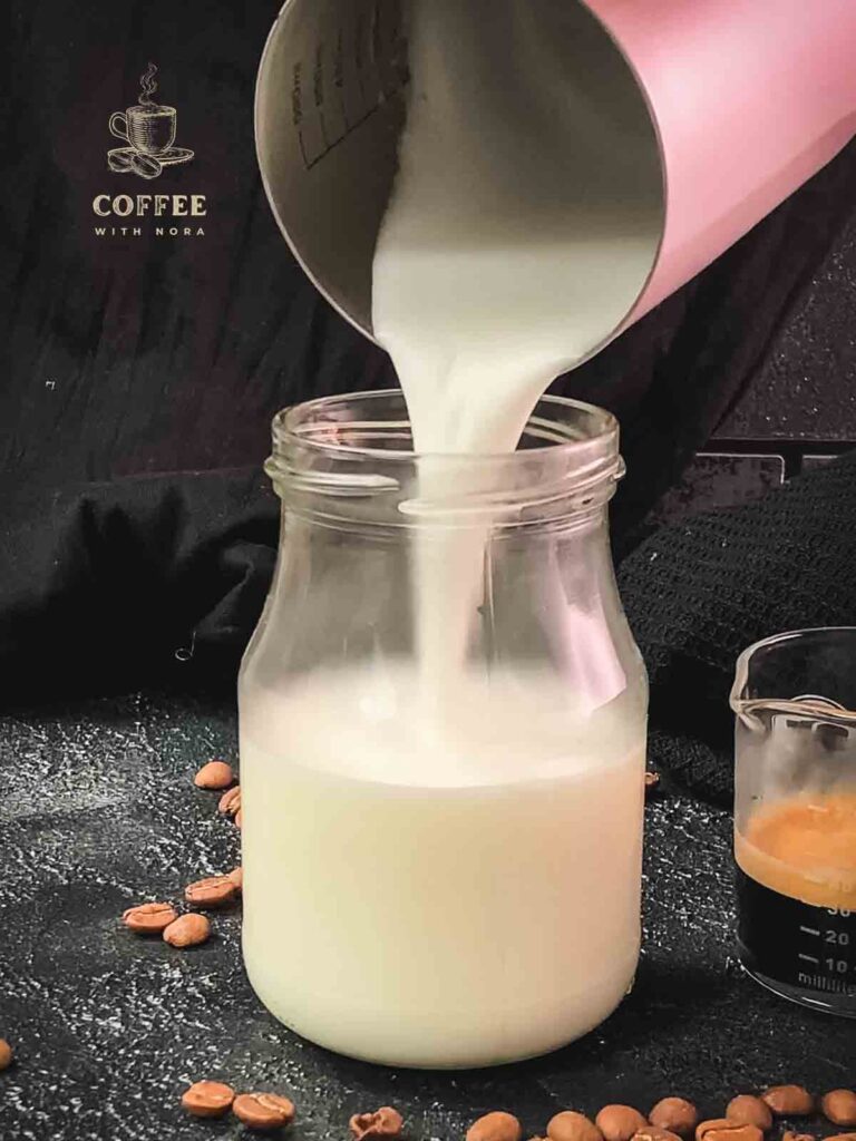 Pouring frothed milk into the glass jar.
